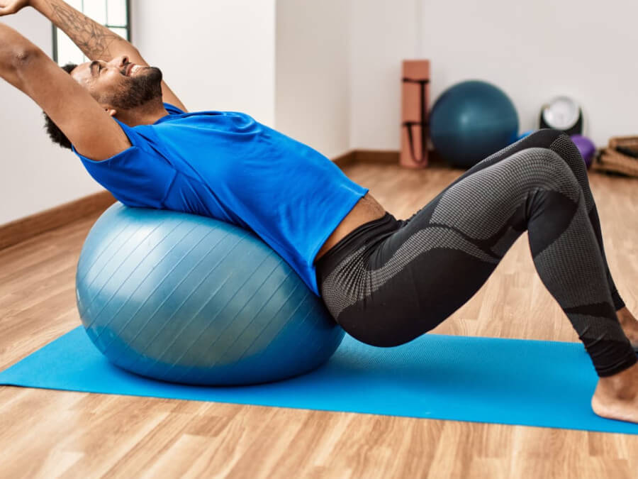 バランスボールを使ってストレッチをする男性